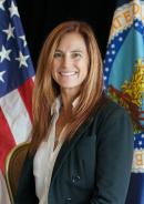 Utah State Director Michele Weaver, light skin female, with straight auburn, shoulder length hair, in front of American flag and Department of Agriculture flag.