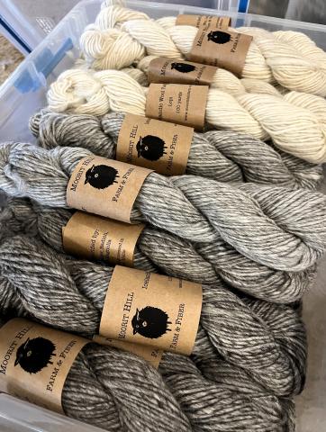 Pictured are skeins of wool yarn in natural colors bearing the Moorit Hill Farm and Fiber label. 