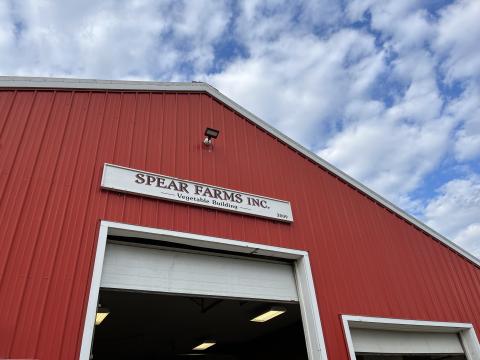 A red barn is shown with a white sign reading Spear Farms Inc.