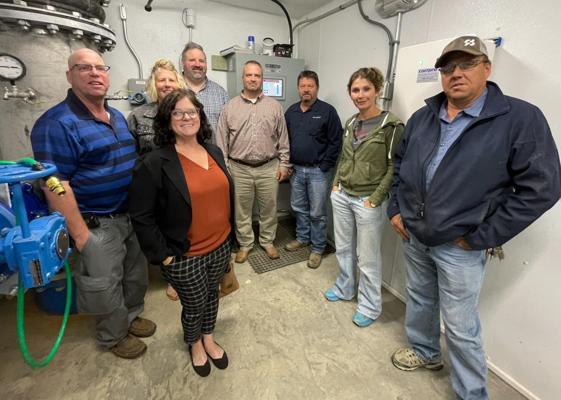 Rural Development and Mni Waste staff inside the pump room of a water tower in Eagle Butte