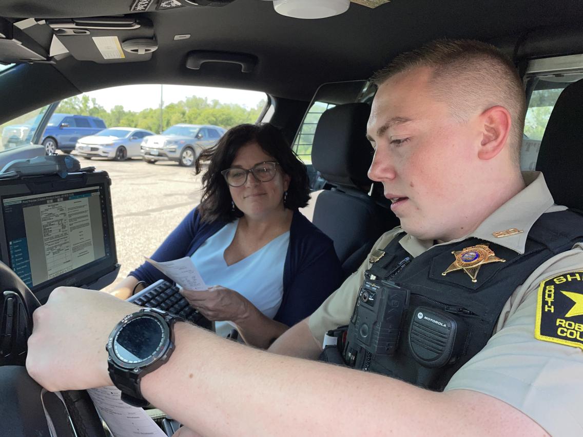 Deputy Mishler with  State Director Gronli inside patrol car.