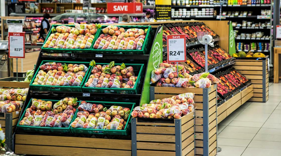 Grocery store produce isle with apples in the forefront
