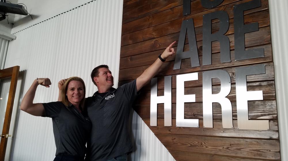 Couple pointing to Nevada shape sign at The Grid Restaurant in Fallon Nevada