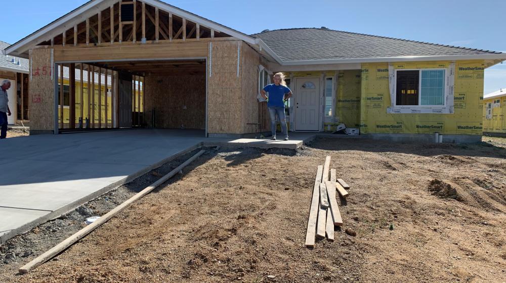 Sherry Parker poses for a photo by the construction of her new home  in Northern Calirfornia. Parker lost her home during the devastation of the Camp Fire in 2018. (USDA Courtesy Photo)