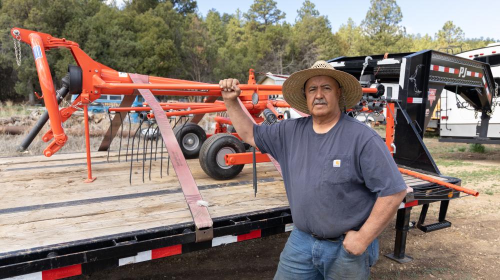 Man stands next to farm equipment
