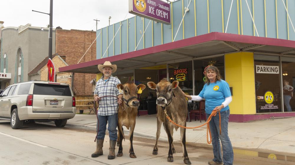 Scott and Melissa Holt with their two cows in front of the Bistro