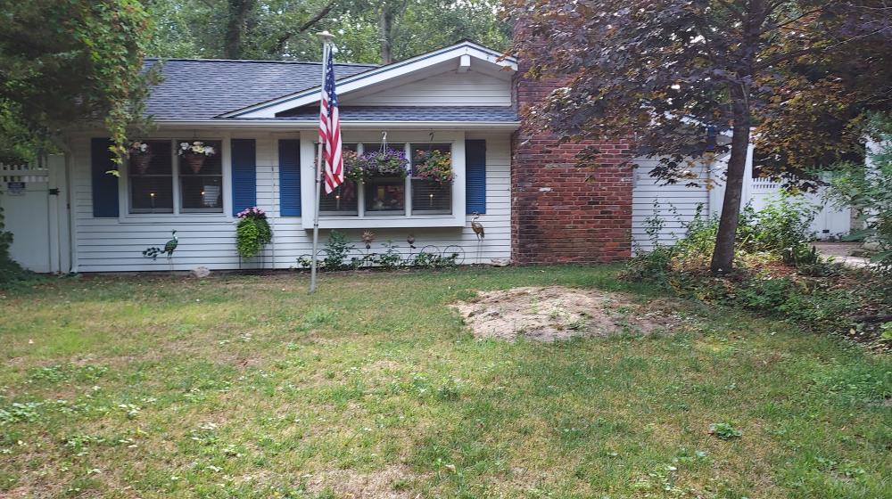 A pretty white home with blue shutters and hanging plants