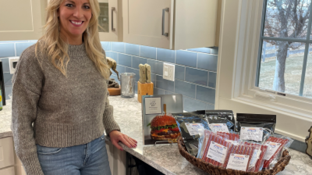 Woman standing in kitchen next to basket of processed meat products