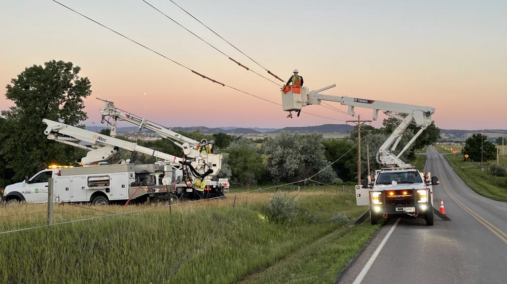 West River Electric Association crews use bucket trucks install power lines in South Dakota