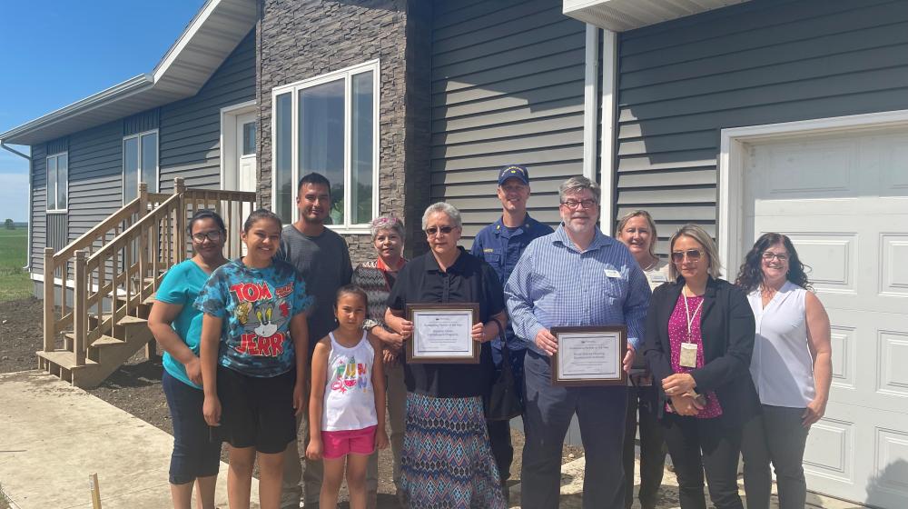 Brian and Catherine Bartunek family with Rural Development staff outside home