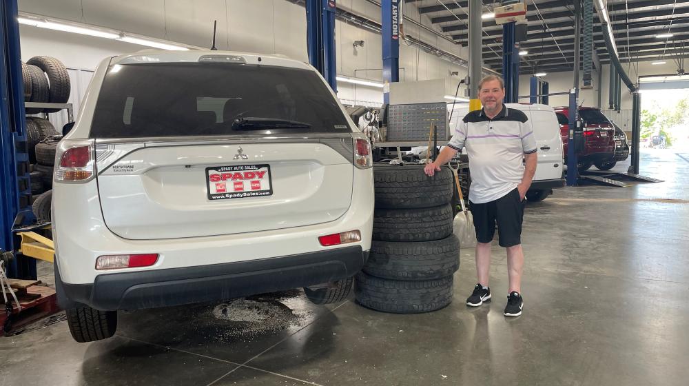 Todd Spady stands next to a vehicle in his family business