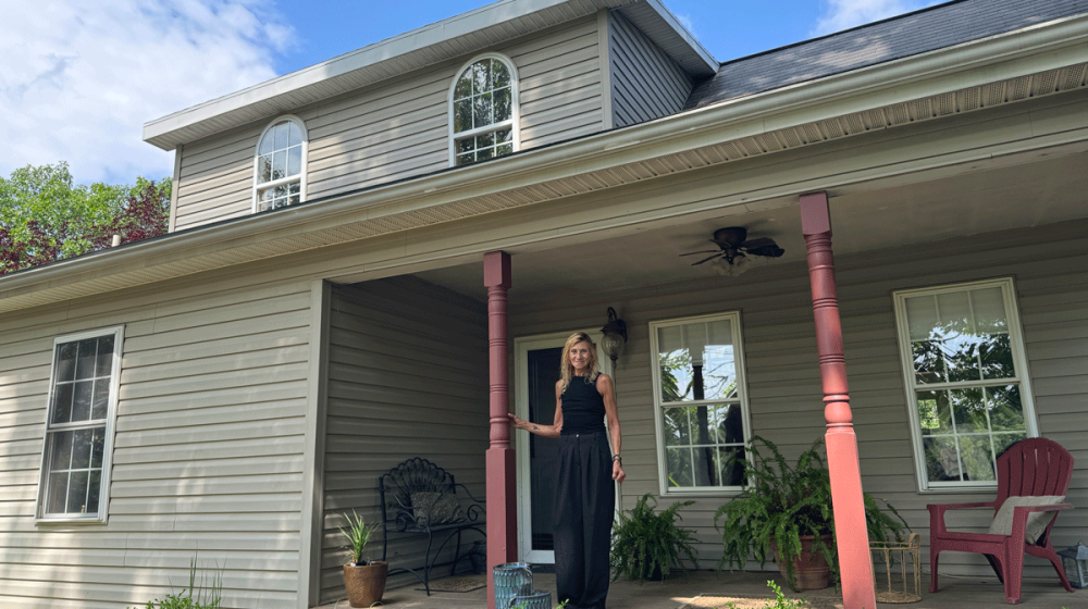 Donna Carpegna stands on the front porch of her home in Fort Ashby, West Virginia. Donna purchased the house with help from a USDA Section 502 Direct Loan.