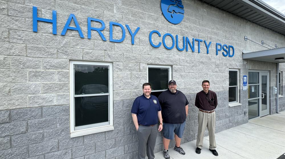 USDA Rural Development West Virginia State Director Ryan Thorn (left), Hardy County Public Service District General Manager Logan Moyers (center), and USDA Rural Development Area Director Steve Collins take a picture in front of the new Hardy County PSD office building in Moorefield, West Virginia.