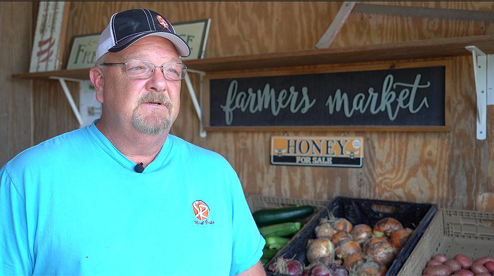 William French standing near produce in his farmers market.