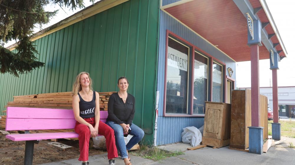 Two women sitting on a pink bench