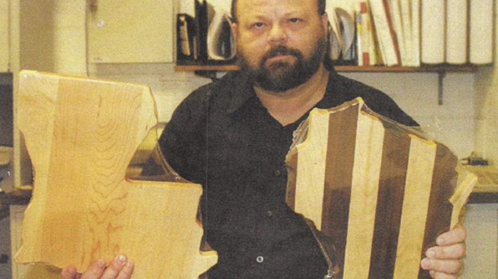 Brian Sinclair holds state shaped cutting boards