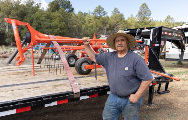 Man stands next to farm equipment