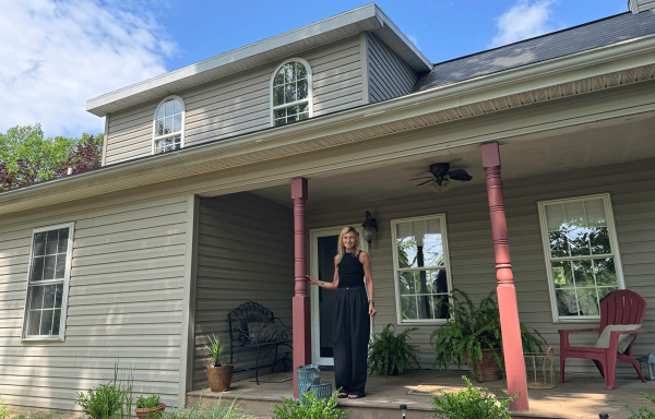 Donna Carpegna stands on the front porch of her home in Fort Ashby, West Virginia. Donna purchased the house with help from a USDA Section 502 Direct Loan.