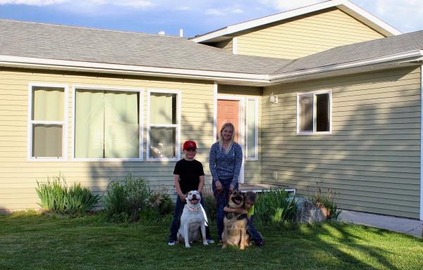 Amanda and her family in front of their new home 